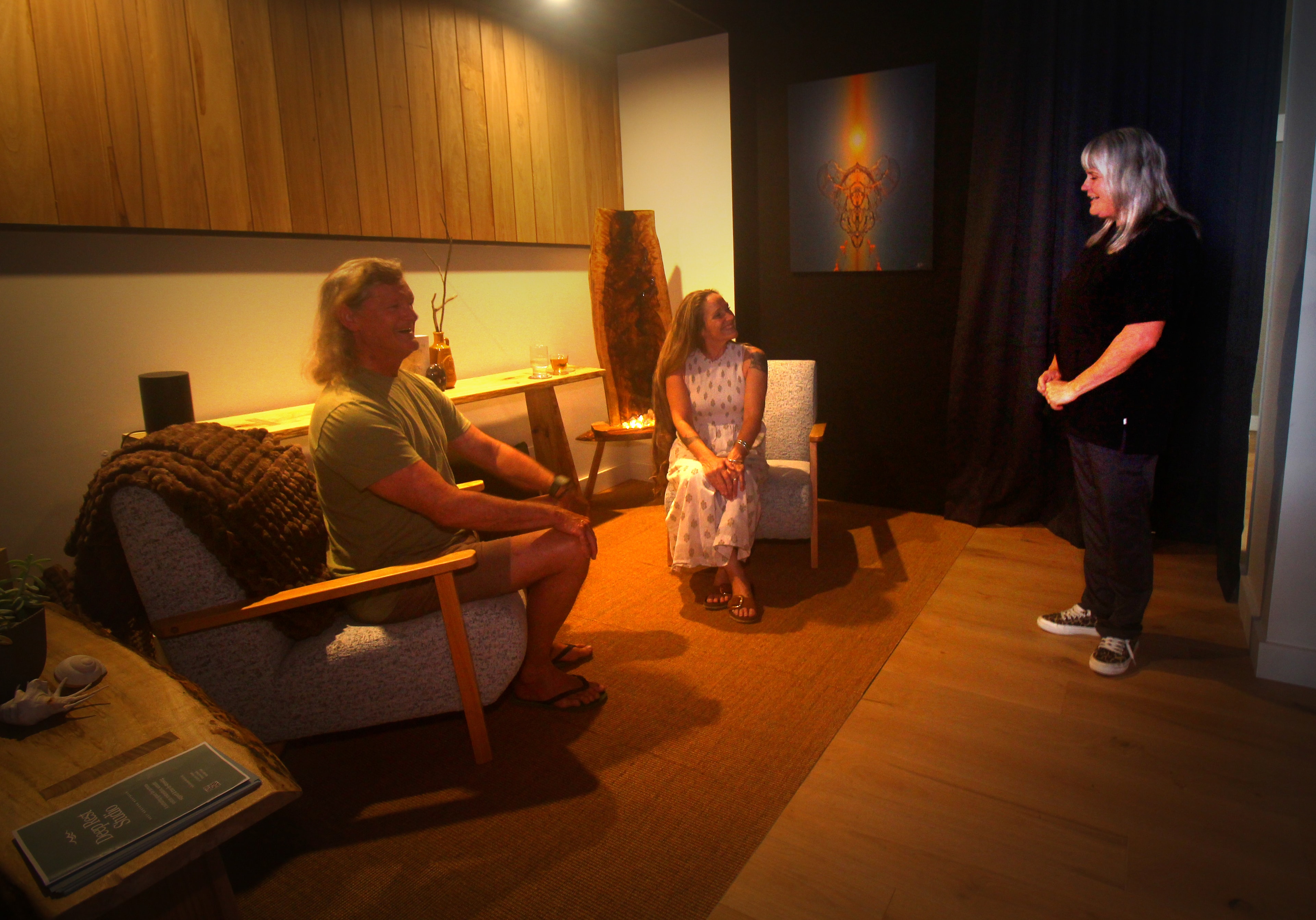 Susannah welcoming guests in the Deep Rest Studio lounge — warm lighting, mid-century chairs