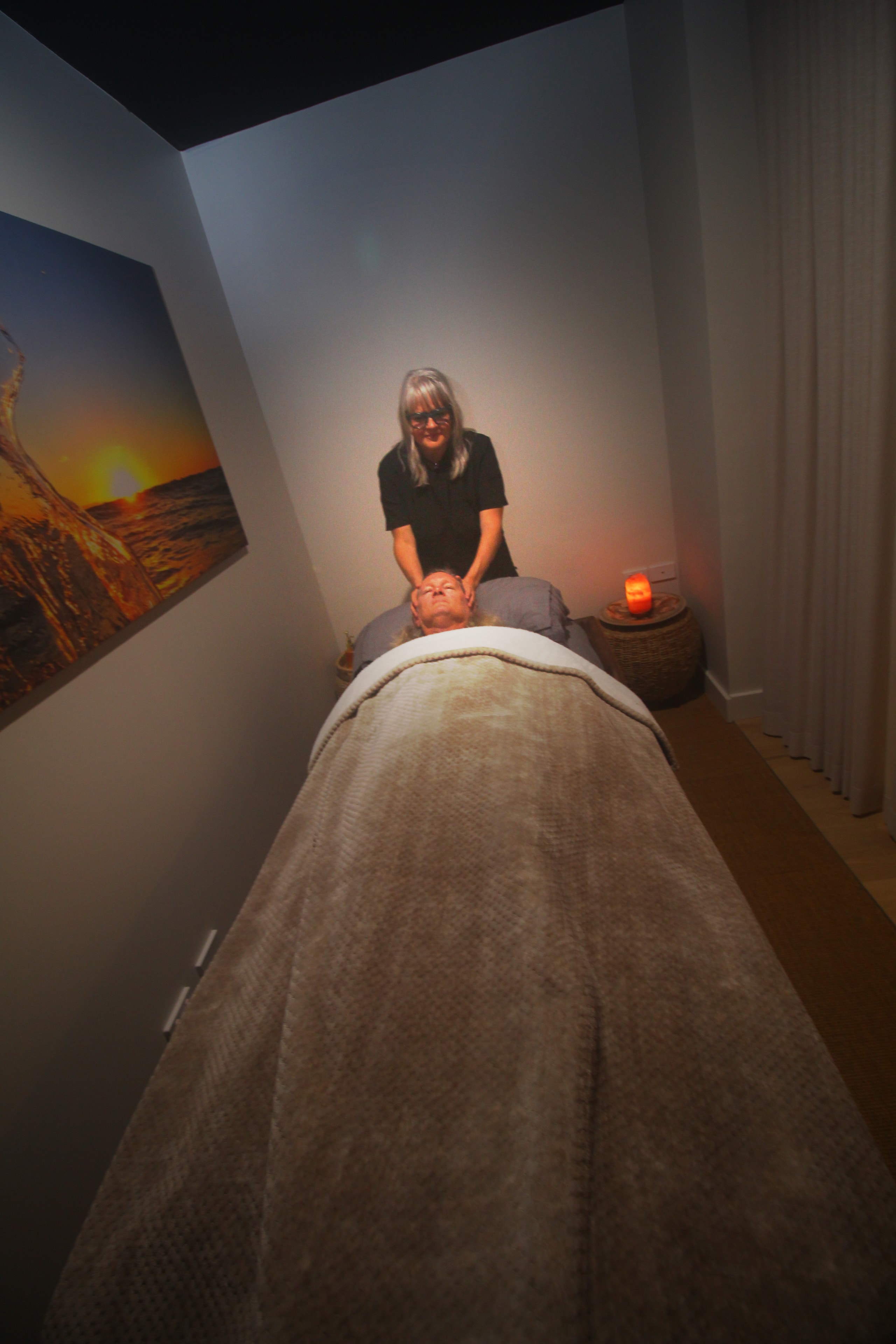 Susannah providing a treatment in the Deep Rest Studio room — salt lamp glow, client at rest